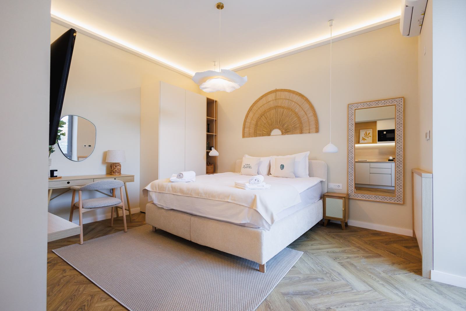 Dormitor cu pat dublu mare, decor din ratan și birou.