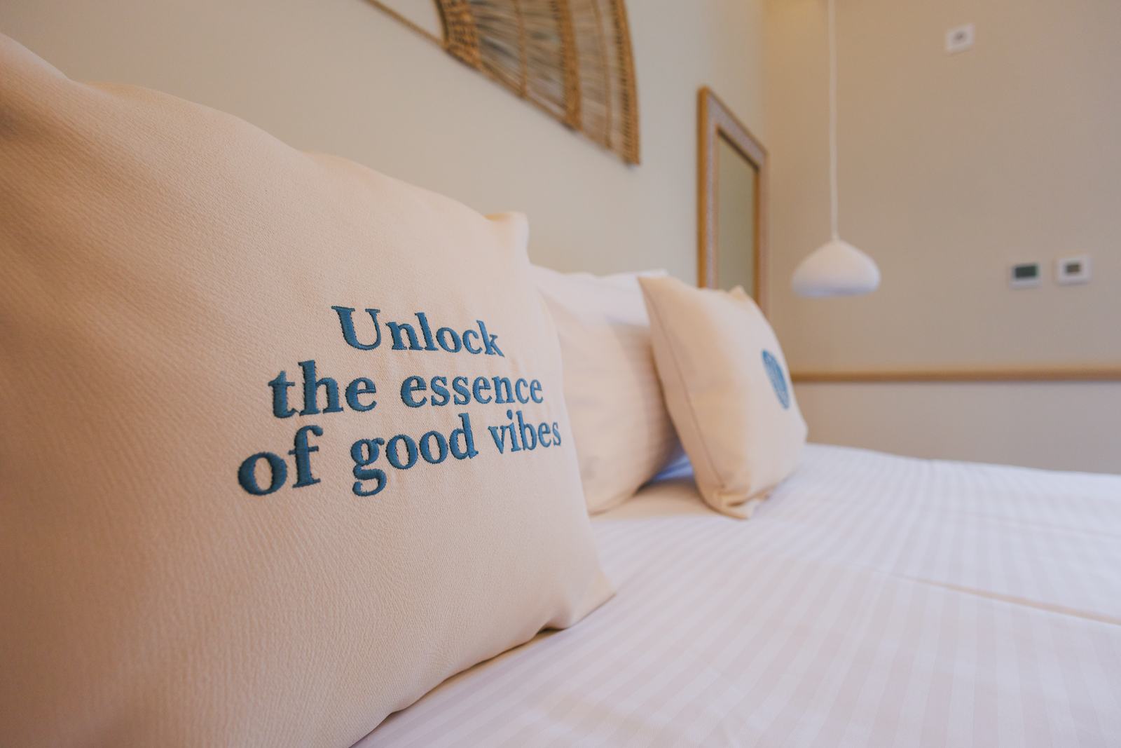 Pernă cu mesajul „Unlock the essence of good vibes”.